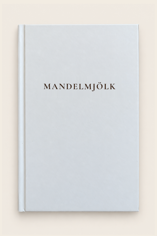 Mandelmjölk anteckningsbok med ljust omslag och mörkbrun titel mot beige bakgrund