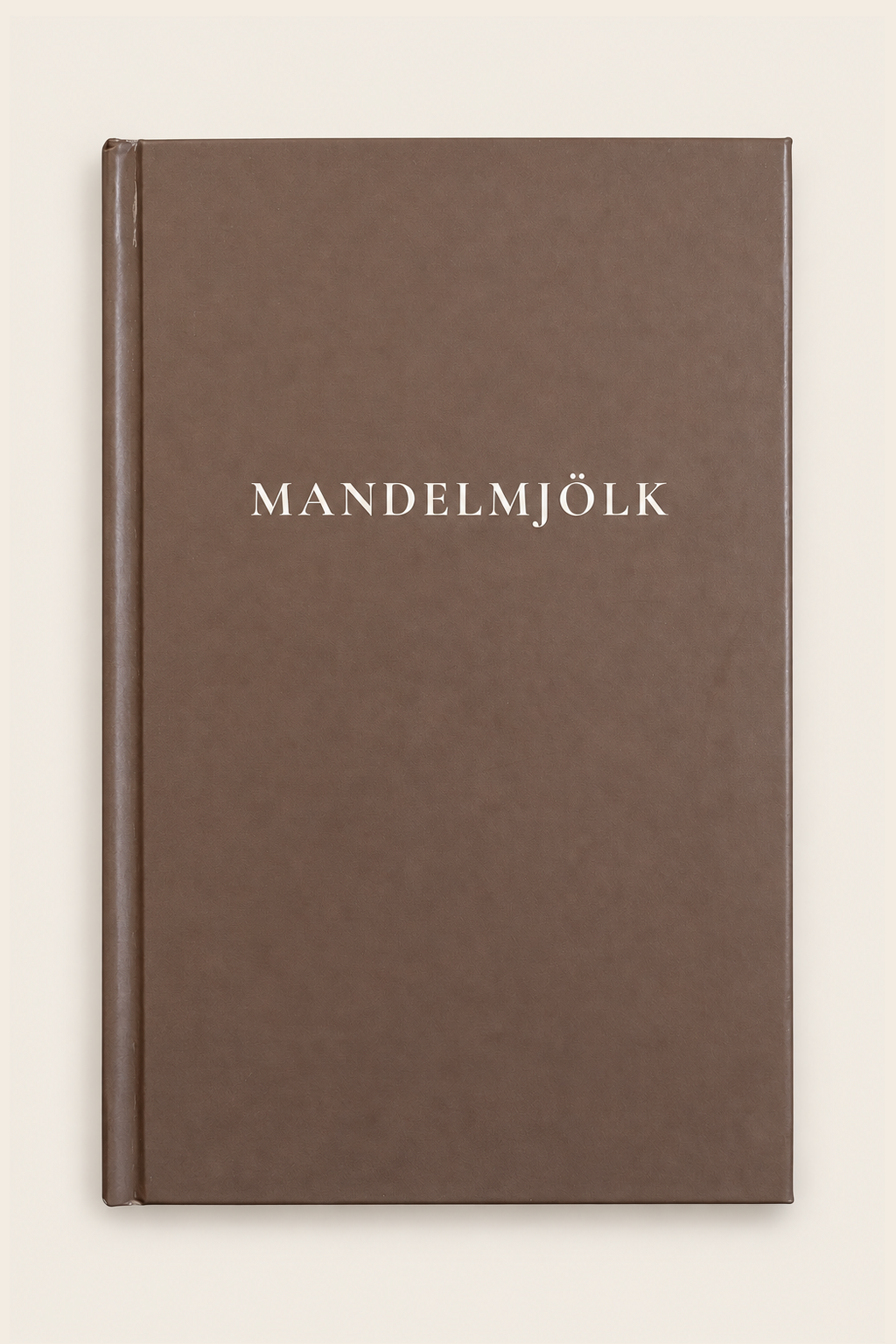 Mörkbrun Mandelmjölk anteckningsbok mot beige bakgrund