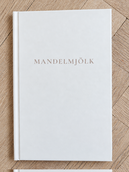 Vit Mandelmjölk anteckningsbok på ljus fiskbensparkett